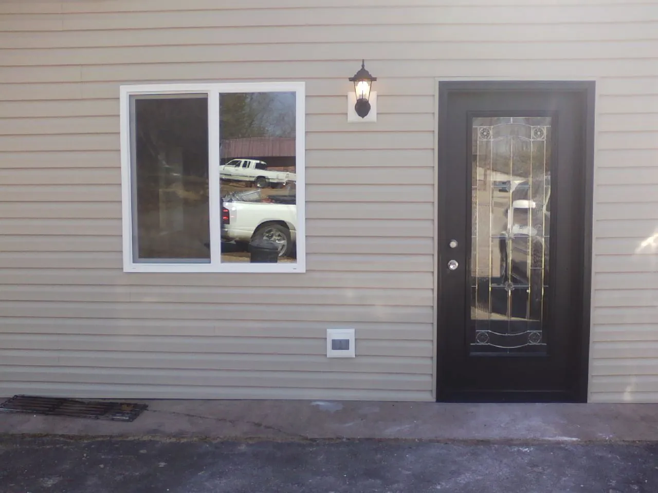 New siding, window and entry door on the side of an addition in Ortonville