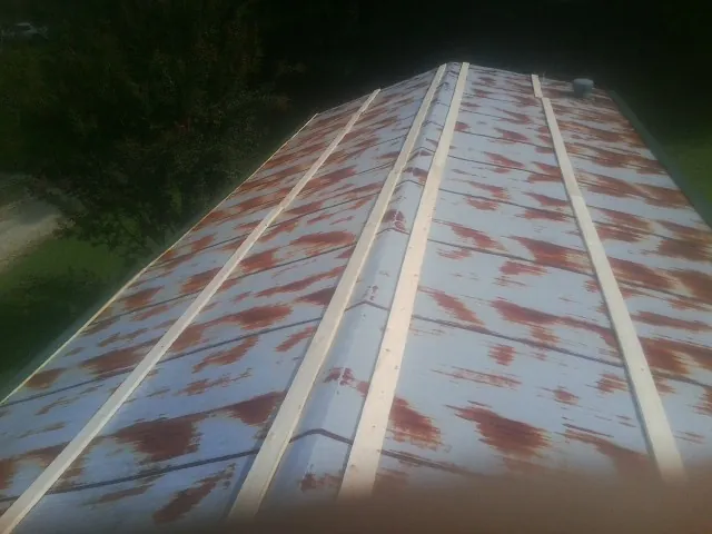 Rusted metal roof panels with new wood purlins before replacement — Storm Damage Roof Repair in Ortonville by Roofing Brothers