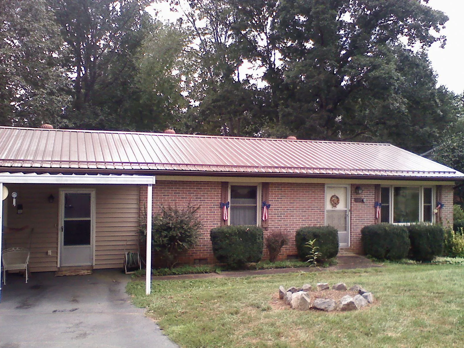 Bronze metal roof and carport on a brick ranch home — Roof Repair work by our crew in Ortonville